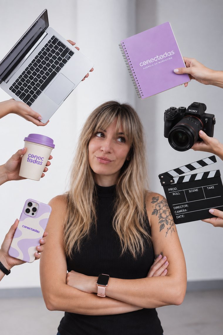 Flor, directora creativa de Conectadas, rodeada de una notebook, un cuaderno, una cámara, una claqueta, un café y un celular
